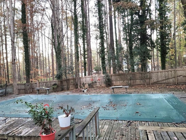 view of pool with a diving board and a deck