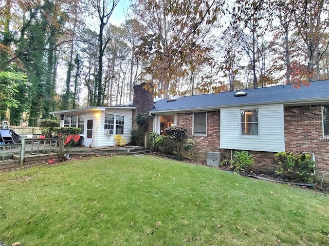 rear view of property featuring a yard and central AC