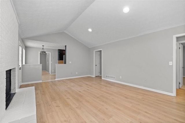 unfurnished living room with lofted ceiling, light hardwood / wood-style flooring, and a fireplace