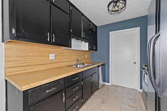 kitchen with light tile patterned flooring, sink, appliances with stainless steel finishes, tasteful backsplash, and a textured ceiling