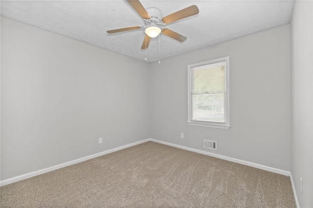 unfurnished room with ceiling fan and carpet