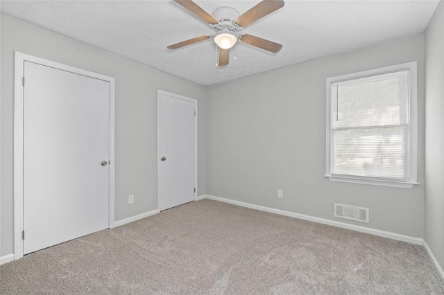 carpeted spare room with ceiling fan