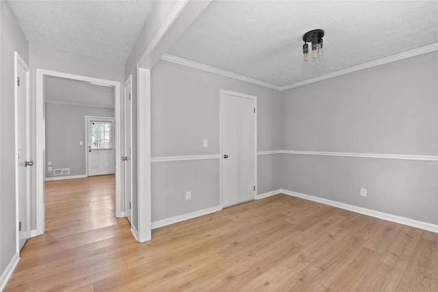 spare room featuring a textured ceiling and light wood-type flooring