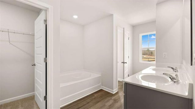 321 Sound Cir, Stockbridge, GA 30281 - full bath with double vanity, a bath, wood finished floors, and a spacious closet
