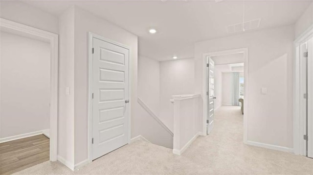 321 Sound Cir, Stockbridge, GA 30281 - hallway with an upstairs landing, light carpet, and recessed lighting