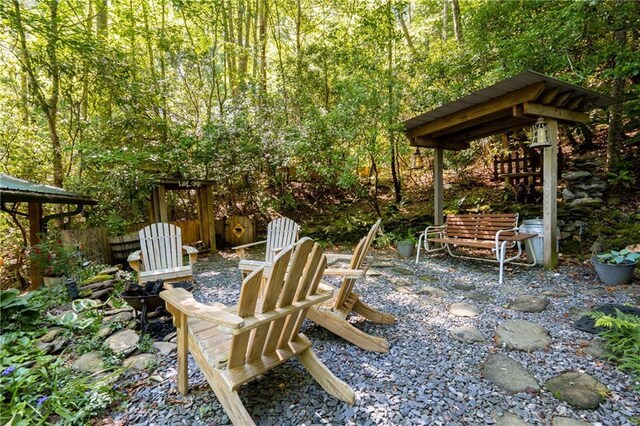 view of yard with a gazebo, a patio area, and a view of trees