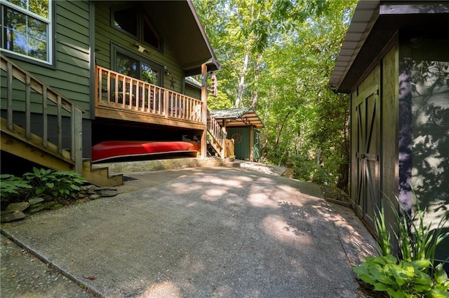 view of property exterior with stairs, a patio, and a wooden deck