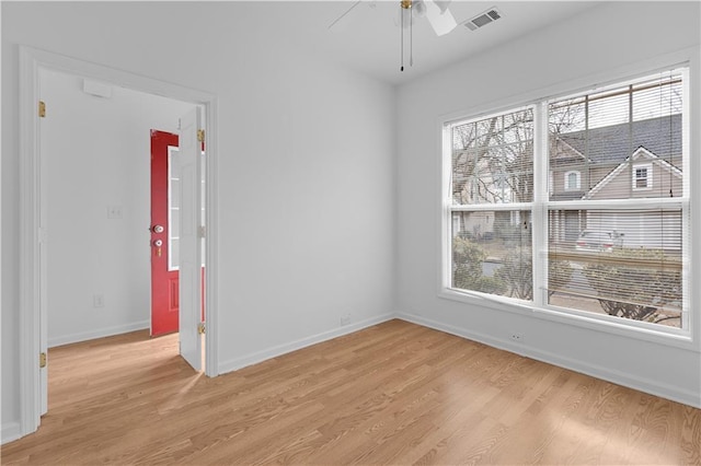 spare room with light hardwood / wood-style floors, ceiling fan, and a healthy amount of sunlight