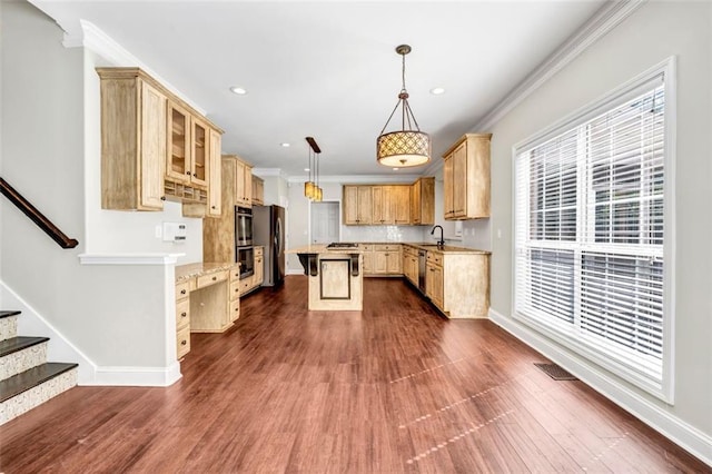 kitchen featuring appliances with stainless steel finishes, dark wood-type flooring, a center island, and pendant lighting