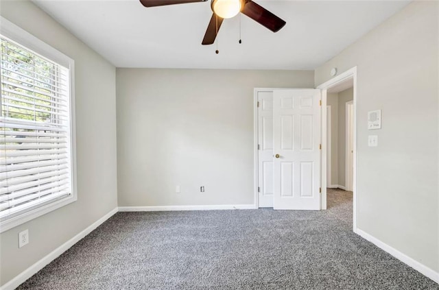 empty room with ceiling fan and carpet flooring