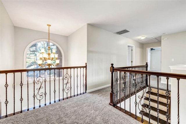 corridor featuring carpet floors and an inviting chandelier