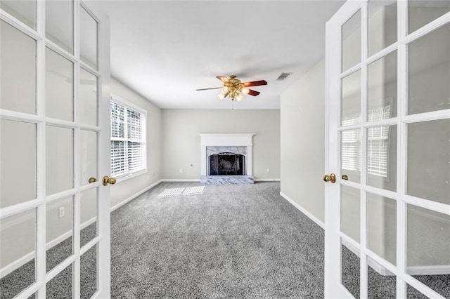 unfurnished living room featuring carpet, a premium fireplace, and ceiling fan