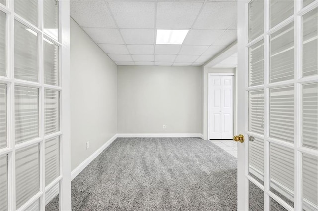 carpeted spare room with a drop ceiling