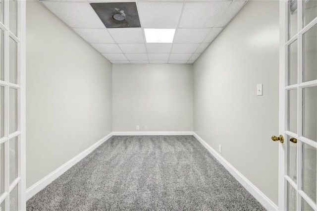 empty room featuring a paneled ceiling and carpet flooring