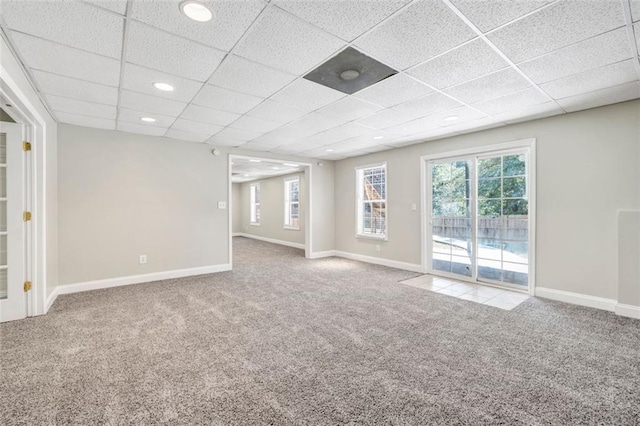 unfurnished room with carpet floors and a drop ceiling