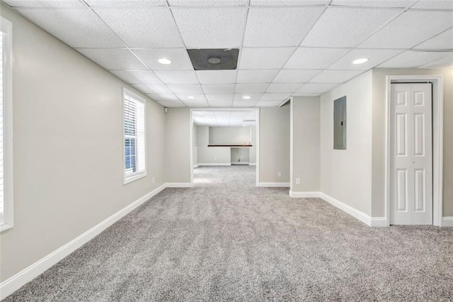 basement with electric panel, a drop ceiling, and carpet floors