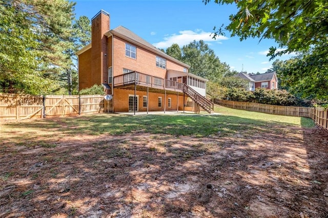 back of house featuring a deck and a lawn