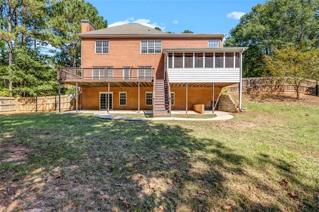 back of house featuring a yard, a sunroom, a patio area, and a wooden deck