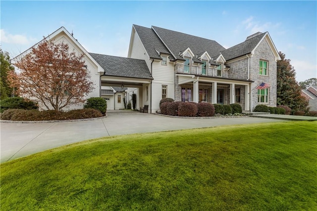 view of front of house with a balcony and a front yard