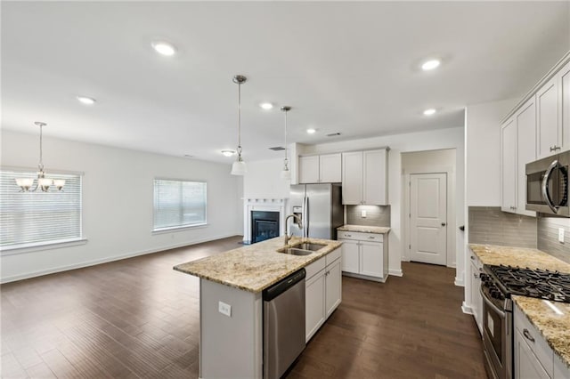 1637 Short Shadow Ln, Snellville, GA 30078 - kitchen featuring stainless steel appliances, a fireplace, tasteful backsplash, a chandelier, and hanging light fixtures
