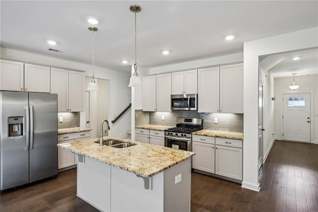 1637 Short Shadow Ln, Snellville, GA 30078 - kitchen featuring appliances with stainless steel finishes, tasteful backsplash, a kitchen island with sink, dark wood-style flooring, and hanging light fixtures