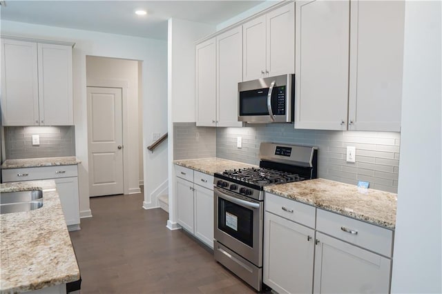 1637 Short Shadow Ln, Snellville, GA 30078 - kitchen with appliances with stainless steel finishes, backsplash, dark wood-type flooring, white cabinets, and recessed lighting