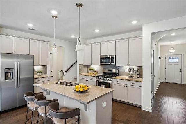 1637 Short Shadow Ln, Snellville, GA 30078 - kitchen featuring stainless steel appliances, backsplash, an island with sink, a kitchen breakfast bar, and hanging light fixtures