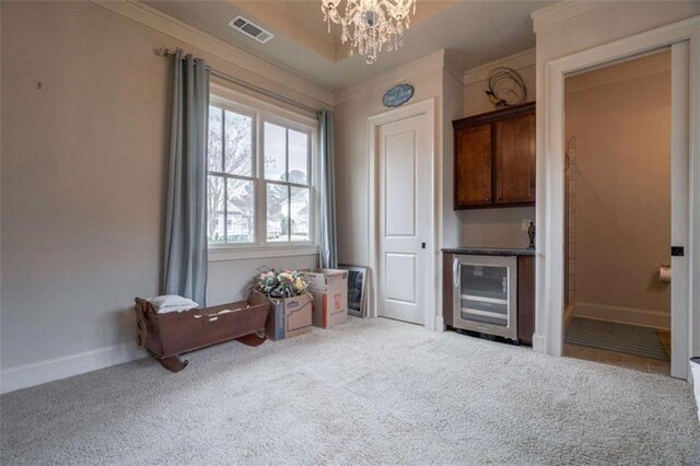 carpeted living room with crown molding, beverage cooler, and a chandelier