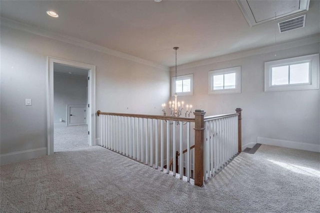 hall with crown molding, carpet flooring, and a notable chandelier