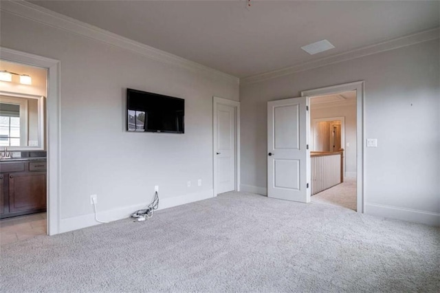 unfurnished bedroom with ornamental molding, light carpet, and ensuite bath