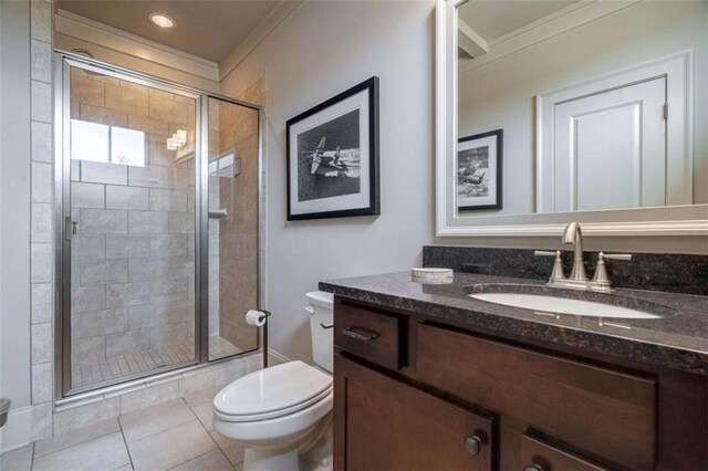 bathroom featuring tile patterned floors, toilet, a shower with shower door, ornamental molding, and vanity