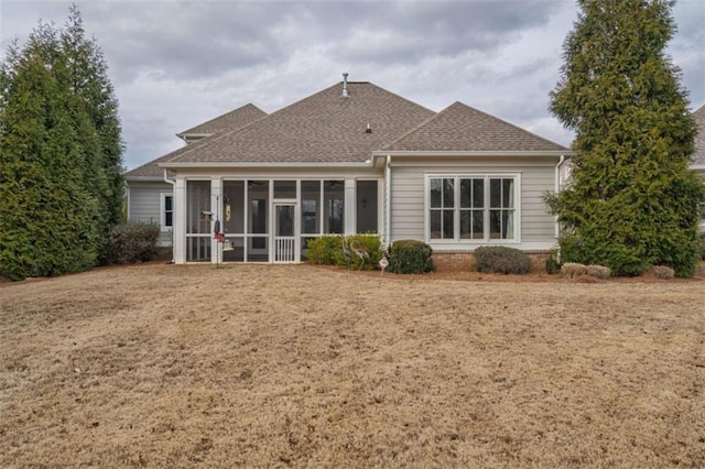 back of property featuring a lawn and a sunroom