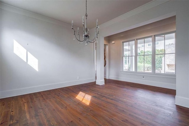 unfurnished dining area featuring dark hardwood / wood-style flooring, crown molding, and an inviting chandelier