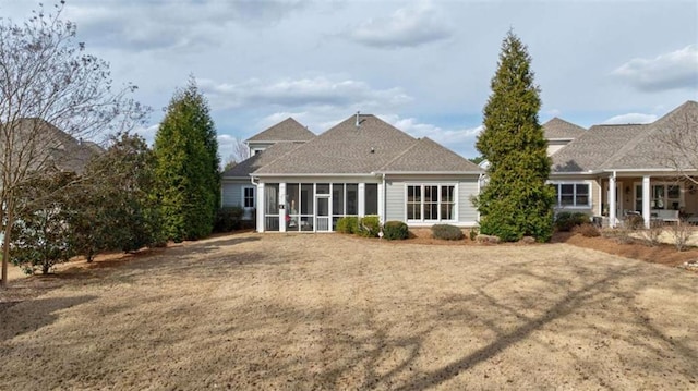 back of house with a yard and a sunroom