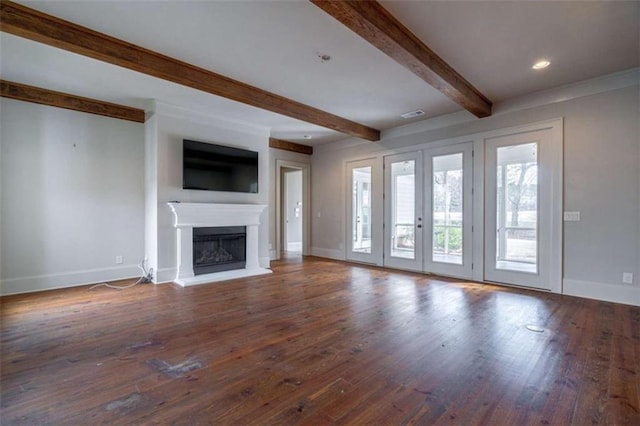 unfurnished living room with beamed ceiling, dark wood-type flooring, and french doors