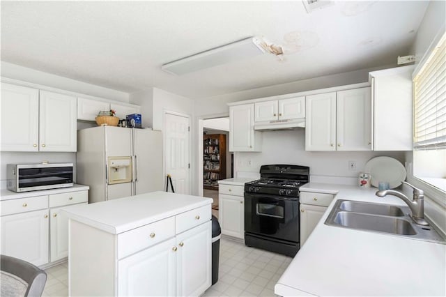 11885 Carriage Park Ln, Duluth, GA 30097 - kitchen with white fridge with ice dispenser, black gas stove, light floors, and under cabinet range hood