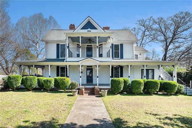 view of front of house featuring ceiling fan, a chimney, a front lawn, and a porch