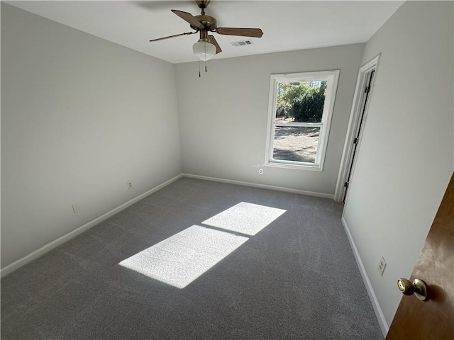 carpeted empty room with visible vents, a ceiling fan, and baseboards