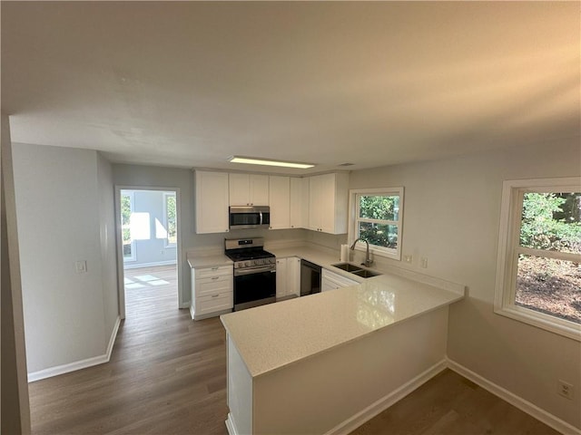 kitchen with a sink, plenty of natural light, appliances with stainless steel finishes, and light countertops