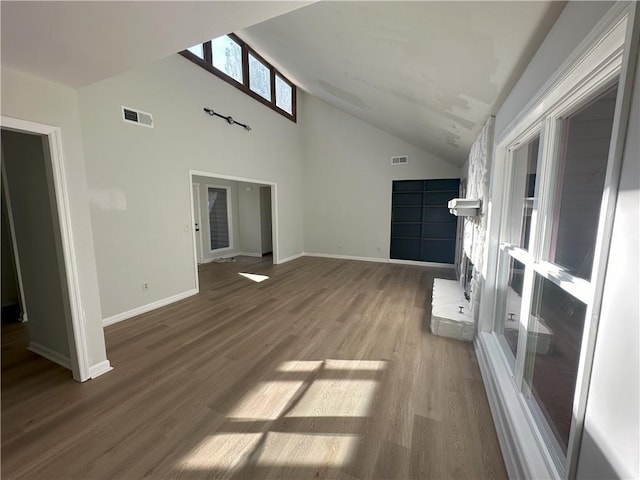 unfurnished living room featuring wood finished floors, visible vents, and baseboards