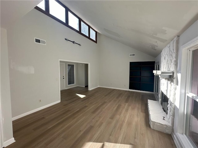 unfurnished living room featuring wood finished floors, visible vents, and baseboards