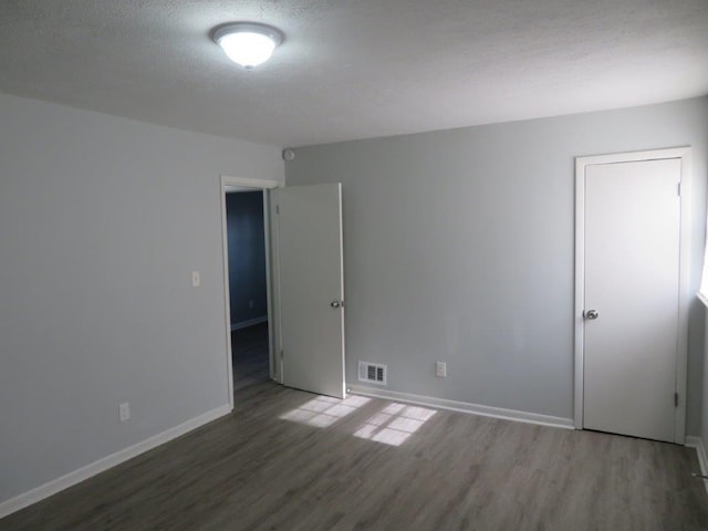 spare room with dark hardwood / wood-style floors