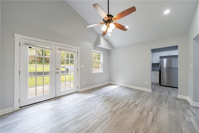 unfurnished living room featuring light wood-style floors, baseboards, high vaulted ceiling, a ceiling fan, and french doors