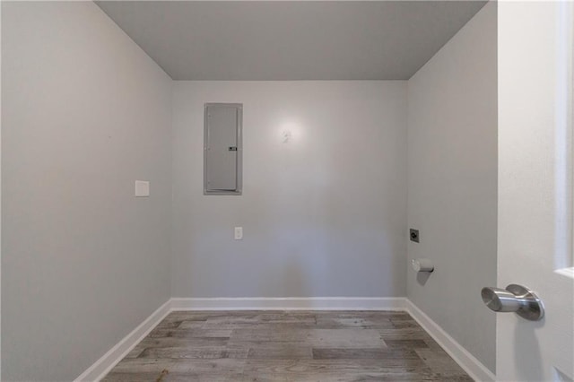 washroom featuring hookup for an electric dryer, electric panel, laundry area, baseboards, and wood finished floors