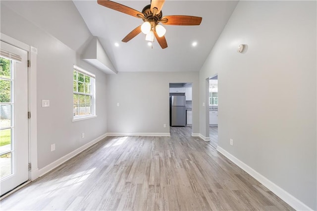 unfurnished living room with light wood finished floors, recessed lighting, ceiling fan, vaulted ceiling, and baseboards