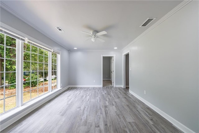 empty room featuring visible vents, a ceiling fan, ornamental molding, and baseboards