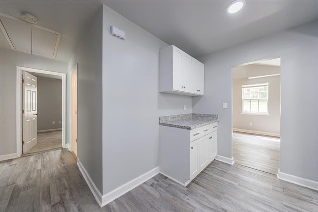 kitchen with baseboards, light wood-style floors, and light countertops