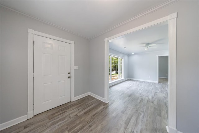 foyer entrance with baseboards, ornamental molding, and wood finished floors
