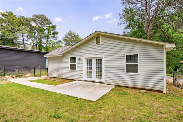 rear view of house with a lawn, a patio area, and fence