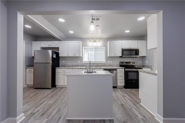 kitchen with visible vents, stainless steel appliances, white cabinets, and a sink
